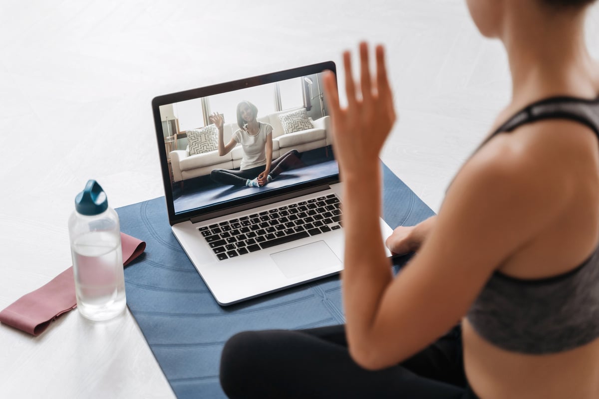 Yoga teacher conducting a virtual class on laptop